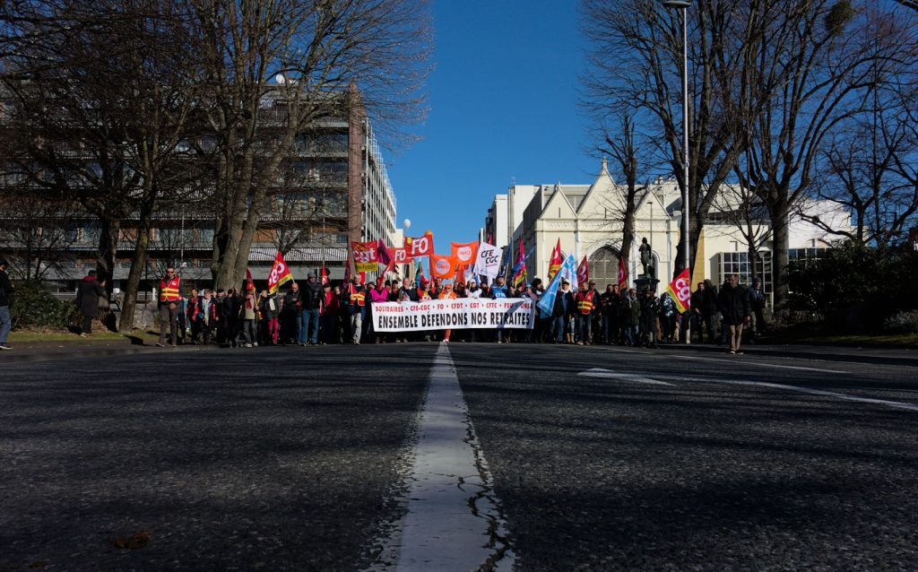 eine Gruppe von Menschen, die am Straßenrand stehen